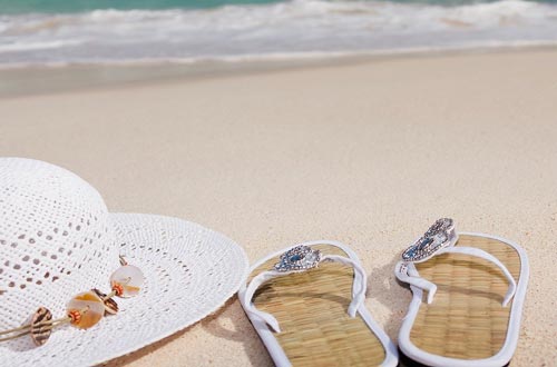 hat and flip flops on beach